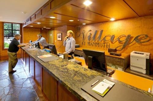 a group of men standing at a counter in an office at The Village Lodge in Mammoth Lakes