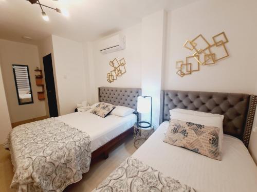 - 2 lits dans une chambre avec 2 lits dans l'établissement Relax Habitación Privada, à Manta