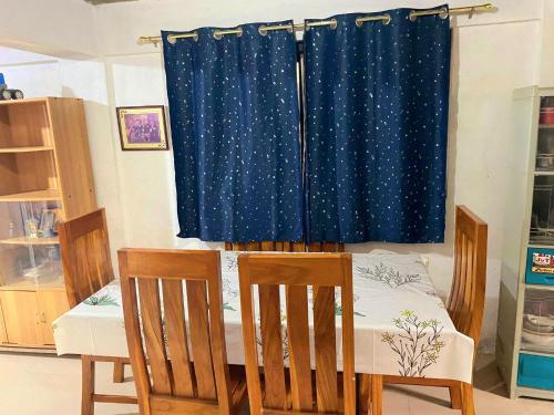 une chambre avec une table, des chaises et un rideau dans l'établissement Eastdee Homestay By Jaya, à Lidlidda
