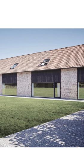 a brick building with windows on the side of it at Les Pommiers in Ellezelles
