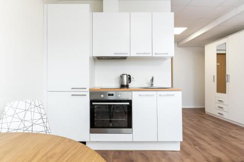 a kitchen with white cabinets and a stove at LKS Apartment one in Tallinn