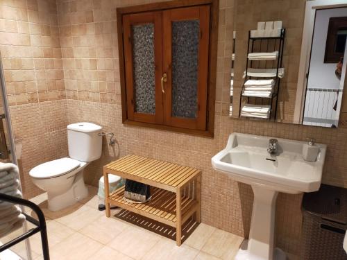 a bathroom with a sink and a toilet and a mirror at Cerezal 1, casa en plena naturaleza 