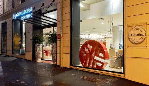 un frente de tienda con una gran señal roja en la ventana en NH Collection Marseille en Marsella