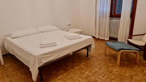 una camera con un letto e una sedia e una finestra di Casa Berizzi - Santa Lucia a Bergamo