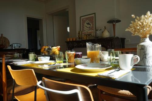 a table with plates and glasses on top of it at La Villégiature in Coutances