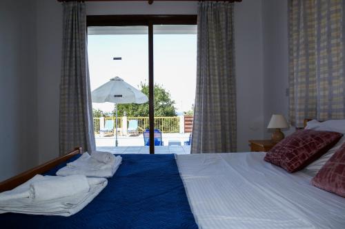 a bedroom with a bed with a view of a patio at VILLA LAMBRIANA in Peyia