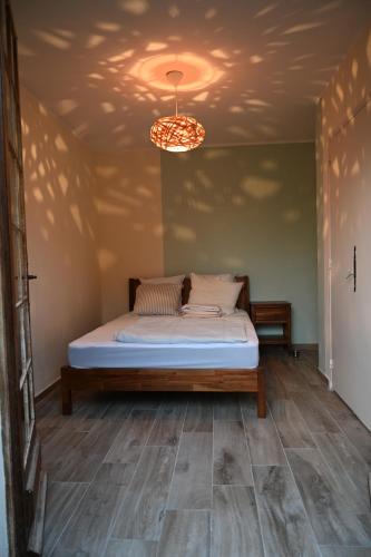 une chambre avec un lit et un lustre dans l'établissement SAKURA, Paisible et confortable appartement à la campagne, à Monteux