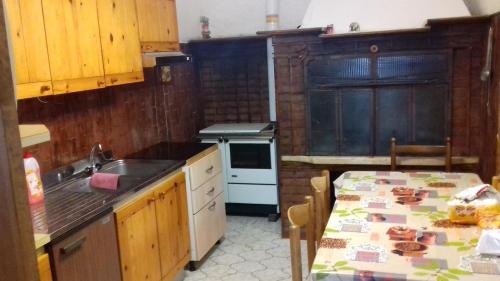 a kitchen with a table and a sink and a stove at Villa Ambra in Vigolo