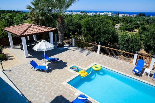 an image of a swimming pool with chairs and an umbrella at VILLA LAMBRIANA in Peyia
