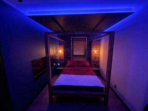 uma cama num quarto com uma luz azul em Apartament Grey Love w Czeladzi, FV, 8km do Katowic em Czeladź