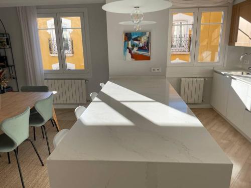 a kitchen with a white counter and a table and chairs at Burgos Señorial by Exclusive Burgos Apartments in Burgos