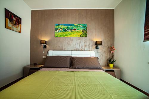a bedroom with a large bed with a green blanket at Terre Etrusche Guest House-Terme -3 minuti da Viterbo centro in Viterbo