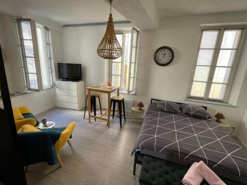 een slaapkamer met een bed en een klok aan de muur bij Le Petit Dijonnais in Dijon