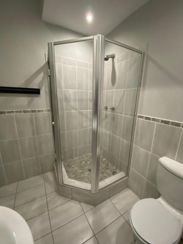 uma cabina de duche na casa de banho com WC em 6th on Brooke av em Joanesburgo