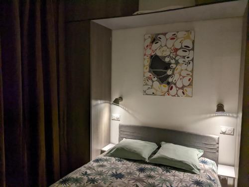 une chambre avec un lit et un tableau au mur dans l'établissement Trocadéro- 2 pièces lumineux, à Paris