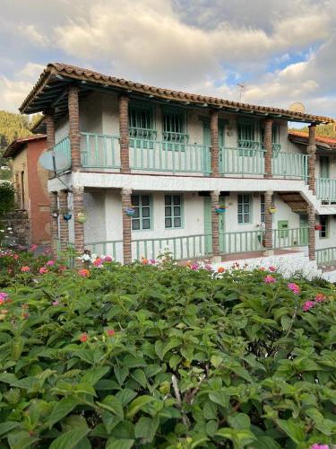 een groot huis met een balkon en bloemen ervoor bij Apartamento En Pueblito Boyacense in Duitama