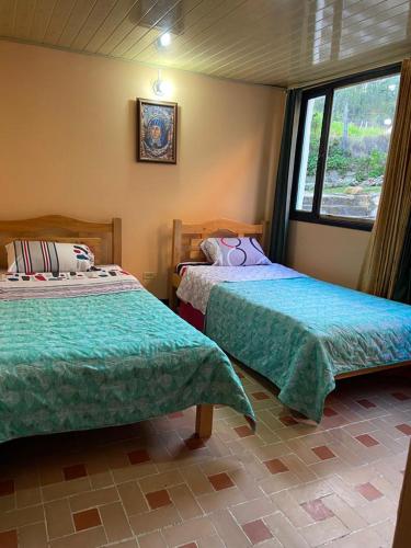 a bedroom with two beds and a window at Apartamento En Pueblito Boyacense in Duitama