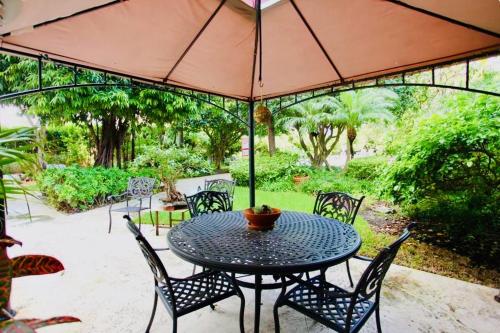 a table and chairs with an umbrella on a patio at Mantell Plaza Apartments in Miami Beach