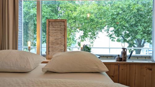a bed with two pillows in front of a window at CRASH'NSTAY - Maison du Ville in Rotterdam