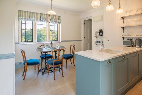 cocina con mesa, sillas y fregadero en Eagles Nest at Greyfriars, en Winchelsea
