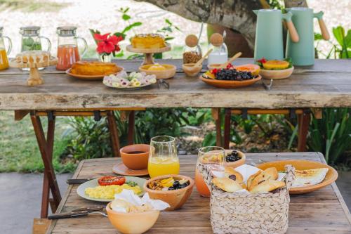 una mesa de picnic con comida y bebidas. en Pousada Quintal Caraíva, en Caraíva