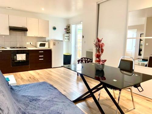 salon ze szklanym stołem i kuchnią w obiekcie Maisonnette Bassin d'Arcachon w mieście La Teste-de-Buch