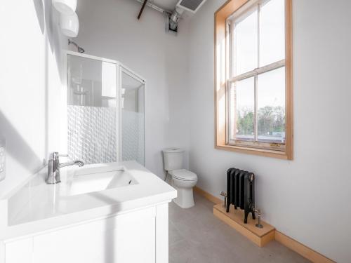 a white bathroom with a sink and a toilet at Sandwich Boutique Hotel in Windsor