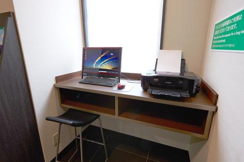 a desk with a laptop computer and a printer at Vessel Inn Hakata Nakasu in Fukuoka