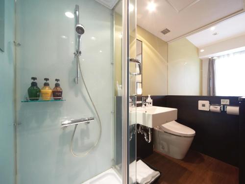 a bathroom with a shower and a toilet and a sink at Vessel Inn Hakata Nakasu in Fukuoka