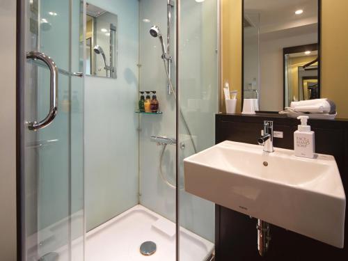 a bathroom with a sink and a glass shower at Vessel Inn Hakata Nakasu in Fukuoka