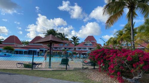 ein Resort mit einem Pool und einigen Palmen und Blumen in der Unterkunft Celadon guadeloupe in Sainte-Anne