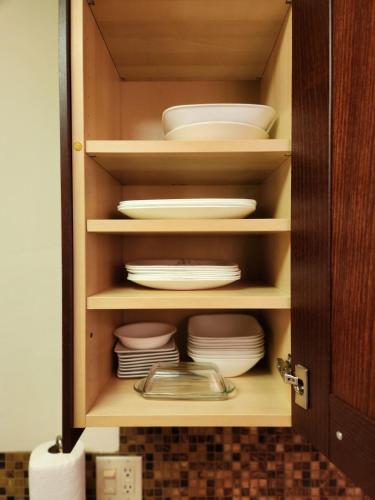 a cupboard with plates and dishes in it at Mantell Plaza Apartments in Miami Beach