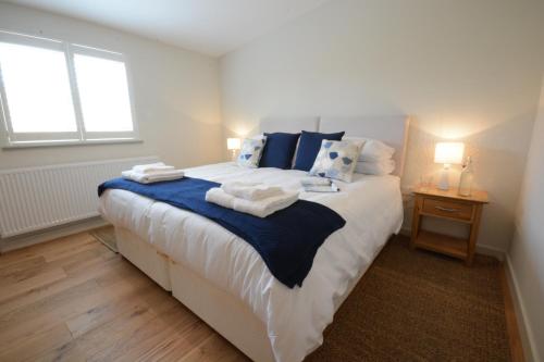 sypialnia z dużym łóżkiem z ręcznikami w obiekcie Muddy Pig, Ubbeston w mieście Laxfield