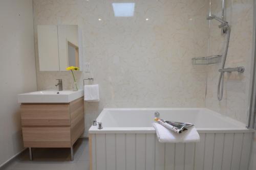 a white bathroom with a tub and a sink at Muddy Pig, Ubbeston in Laxfield