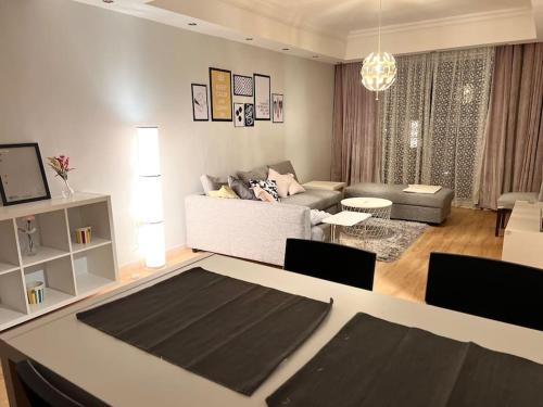 un soggiorno con divano e tavolo con sedie di Ronza Elegant Apartment ad Amman