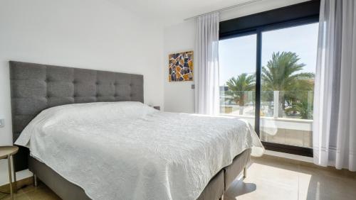 a bedroom with a large bed and a large window at Casa Paraiso de San Pedro in San Pedro del Pinatar