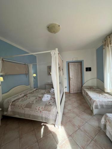 two beds in a bedroom with blue walls at Hotel Tabby in Golfo Aranci