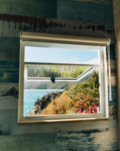 a window in a bathroom with a view of the ocean at Casa Grega in Arraial do Cabo