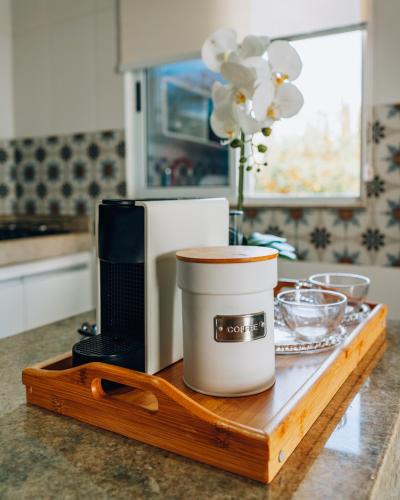 a counter top with a coffee maker and a microwave at Casa Grega in Arraial do Cabo