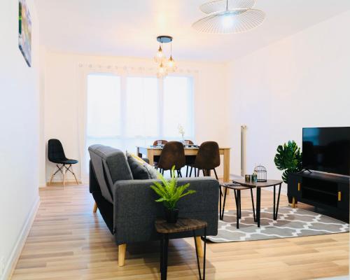 een woonkamer met een bank en een tafel bij Bella Luna II - Elégant appartement centre ville - Parking gratuit - Wifi ultra rapide-Appareil Massage-Netflix-Jeu société in Troyes