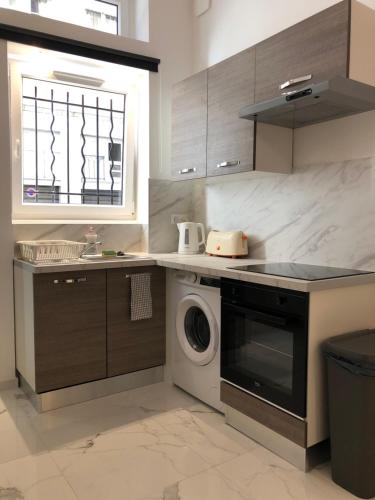 une cuisine avec une machine à laver et une fenêtre dans l'établissement L Ancien Canut Cosy, à Lyon
