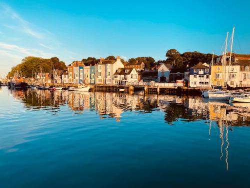 un groupe de maisons et de bateaux sur une masse d'eau dans l'établissement Self Contained Guest suite 2 - Weymouth, à Weymouth