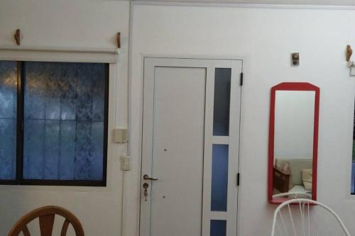 Habitación con puerta blanca y espejo. en Casa alojamiento Sweet IZABEL en Chascomús