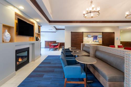 a lobby with a couch and chairs and a fireplace at Holiday Inn Express State College at Williamsburg Square by IHG in State College
