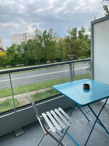 uma mesa azul e uma cadeira numa varanda em Grand appartement entier situé à aulnay-sous-bois em Aulnay-sous-Bois
