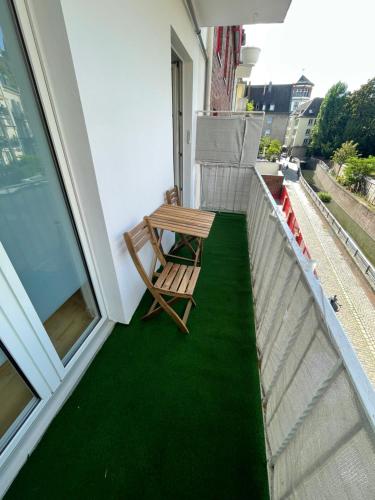 a bench on a balcony with a green floor at Altstadt Apartment, 15 zur Messe in Düsseldorf