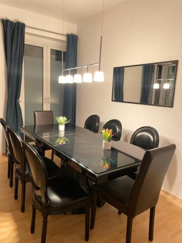 a dining room with a black table and chairs at Altstadt Apartment, 15 zur Messe in Düsseldorf