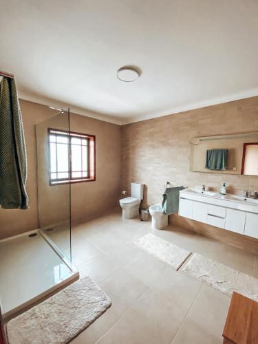 a bathroom with a shower and a toilet and a sink at Casa Riamar in São Jacinto