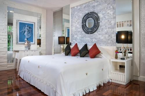 1 dormitorio con 1 cama blanca grande con almohadas rojas en Sireeampan Boutique Resort and Spa - SHA Extra Plus, en Chiang Mai