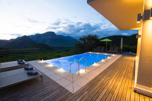 a swimming pool with a view of the mountains at umVangati House in Hoedspruit